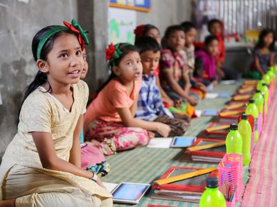 Children in a BRAC classroom with tablets and learning materials