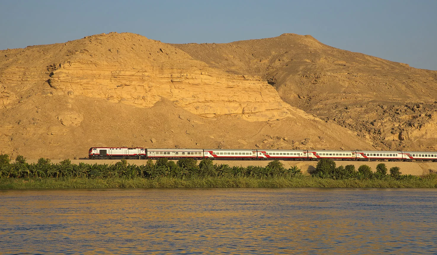 Egyptian train traveling along the Nile Valley for a cheap trip in Egypt