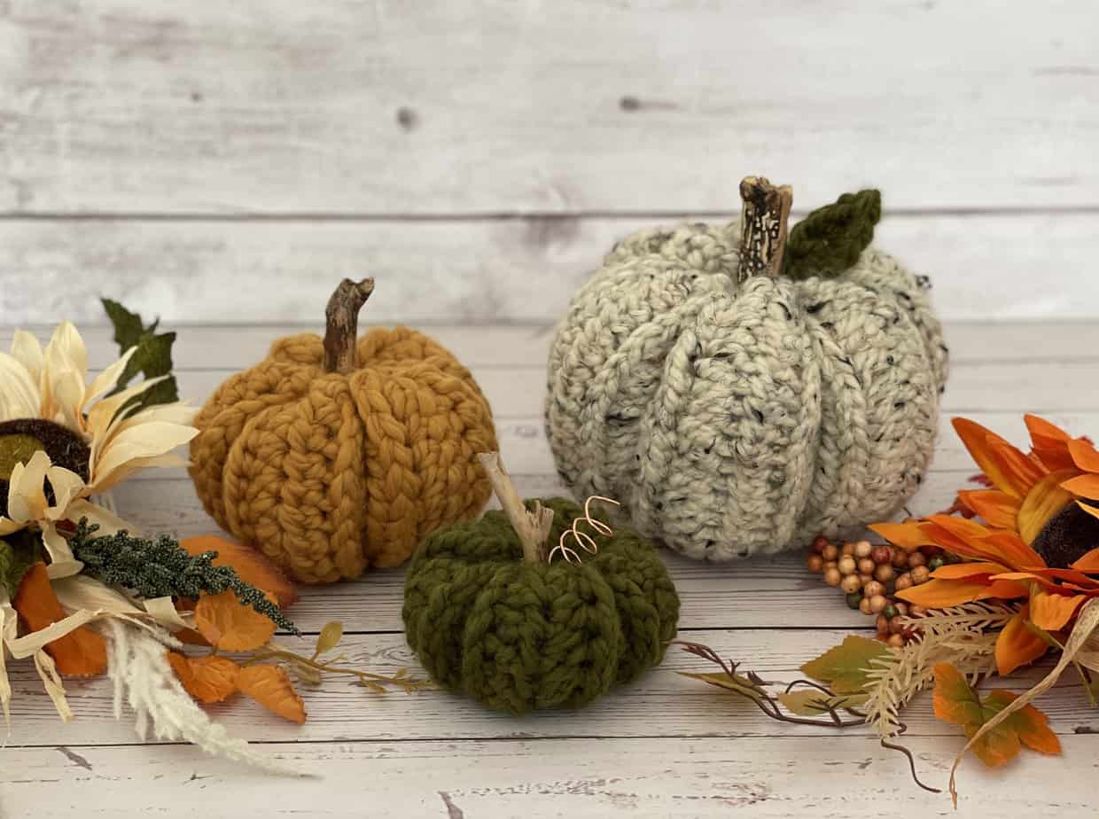 Striped fall crochet blanket draped over wooden crate with pumpkins, cottagecore autumn decor