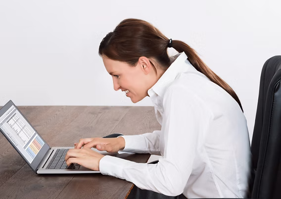 Mulher usando notebook e sentindo desconforto nas costas