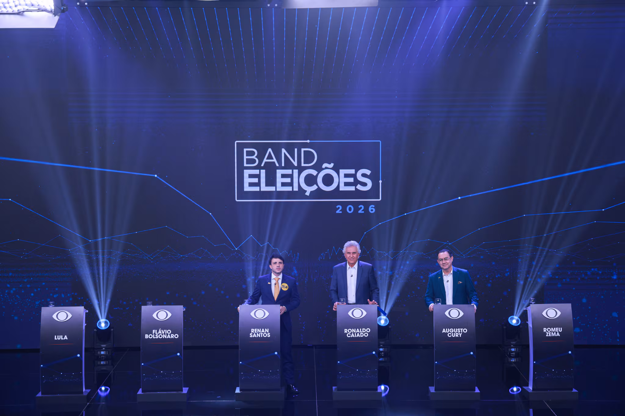 Debate eleitoral Band Eleições 2026 com candidatos Flávio Bolsonaro, Renan Santos, Ronaldo Caiado, Augusto Cury e Romeu Zema em estúdio