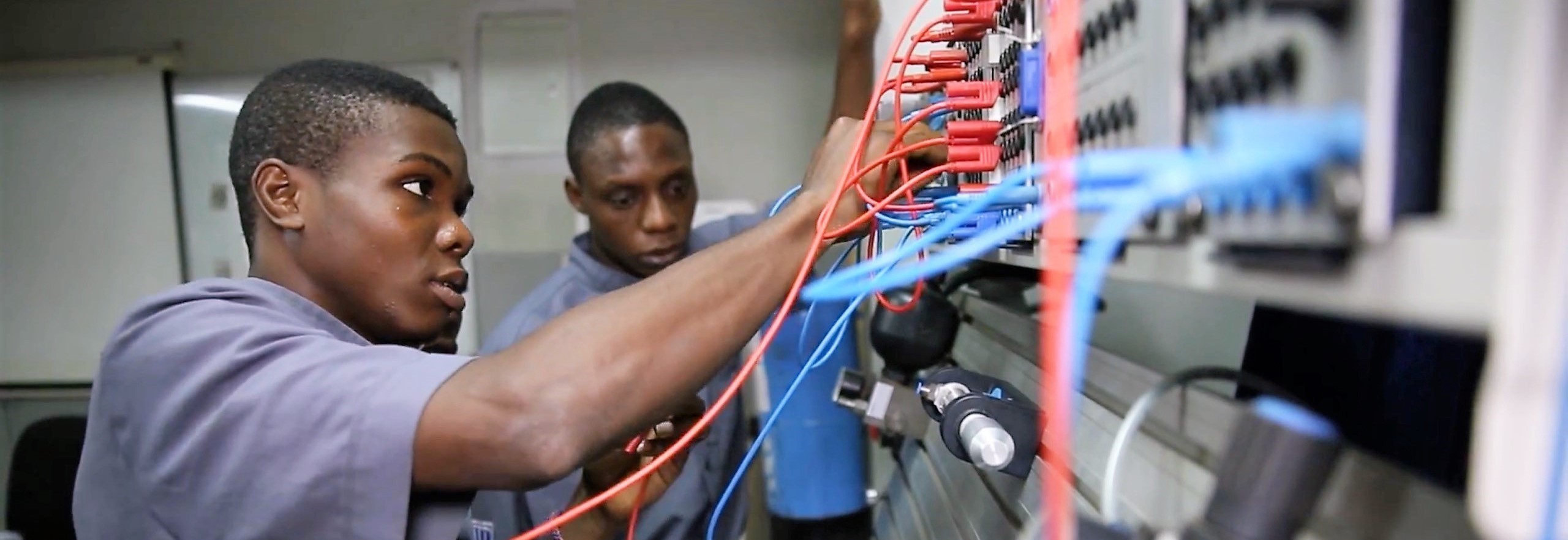 Electrical technician trainees working on industrial control panel wiring in Nigeria technical institute